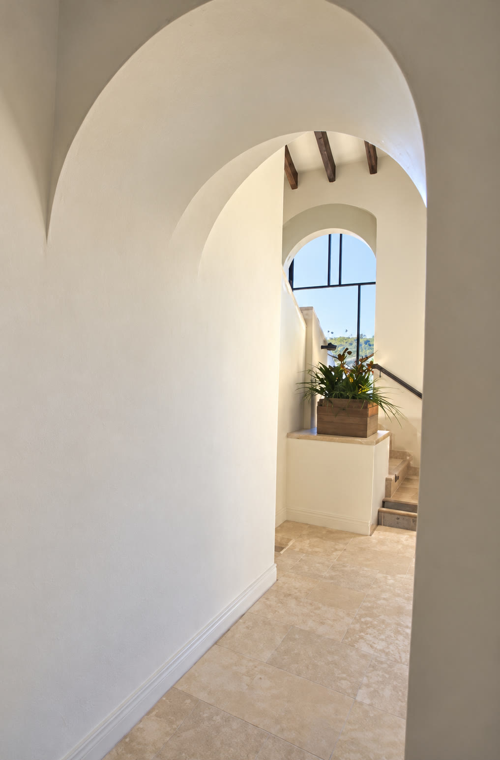 Softly curved hallway arches and stone flooring