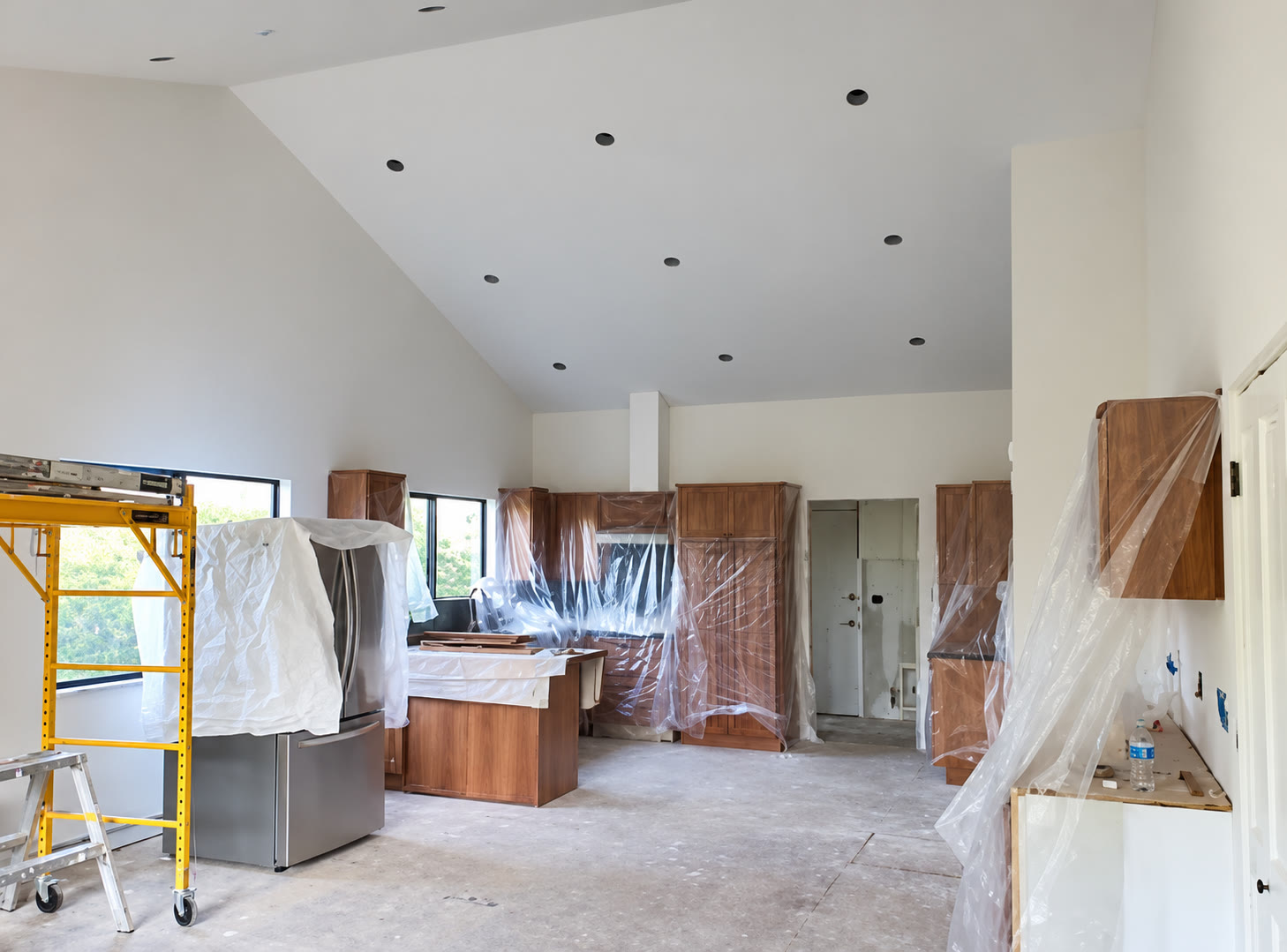 Kitchen renovation with protected cabinetry and unfinished fixtures