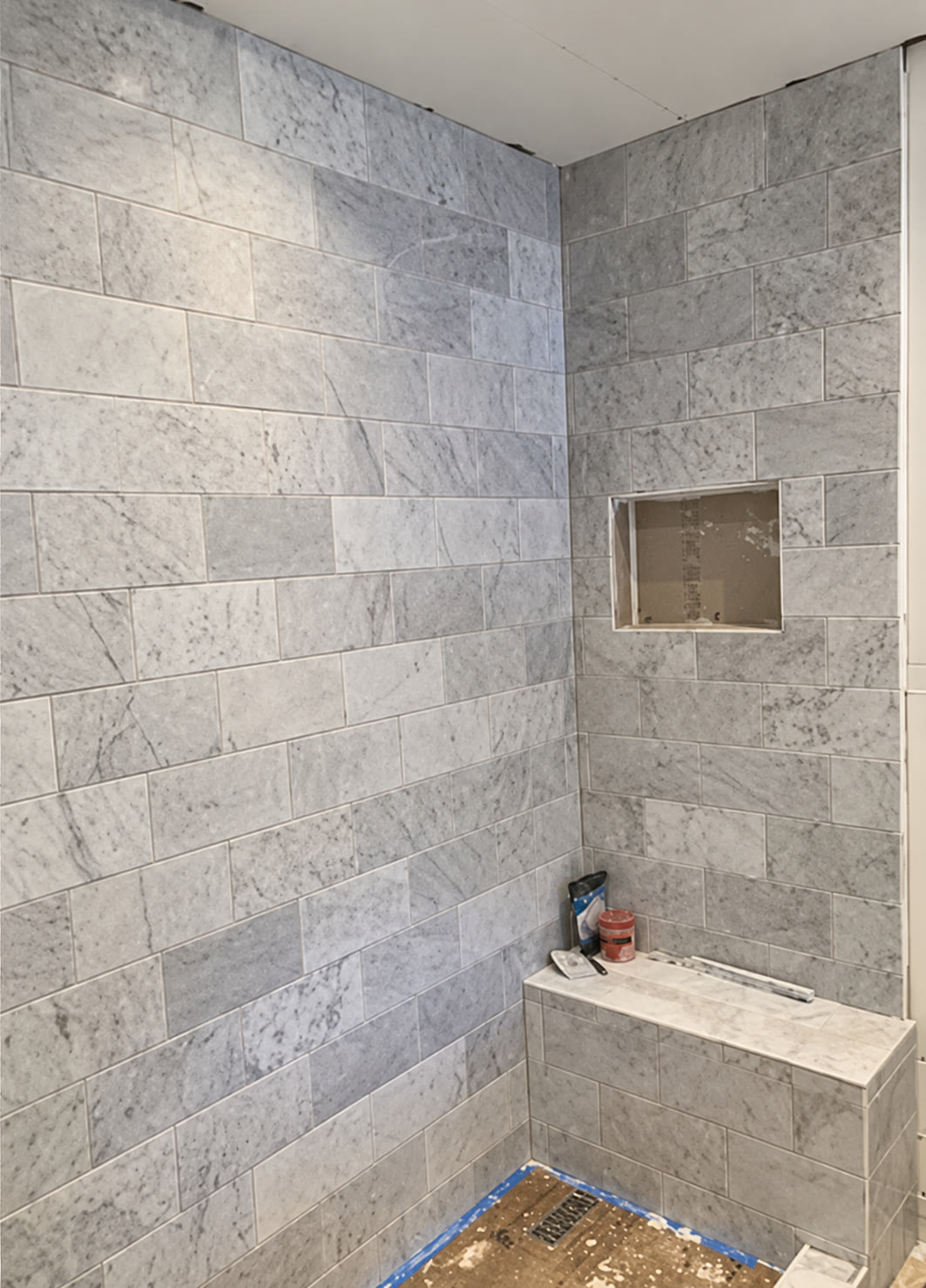 Shower tile installation with a recessed niche and bench