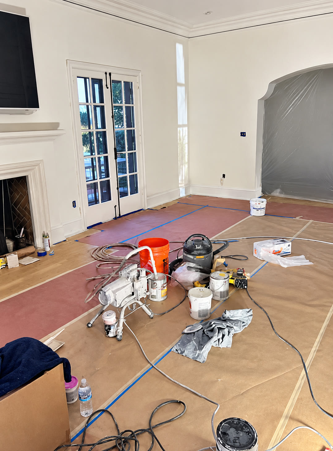 Living room prepared for painting with tools and protective coverings