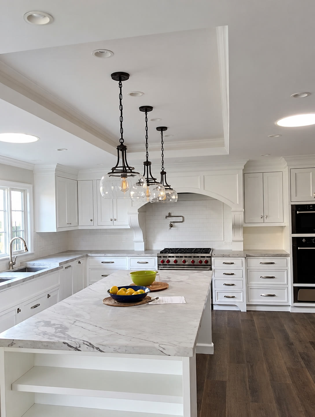 Finished white kitchen with marble-look island and pendant lighting