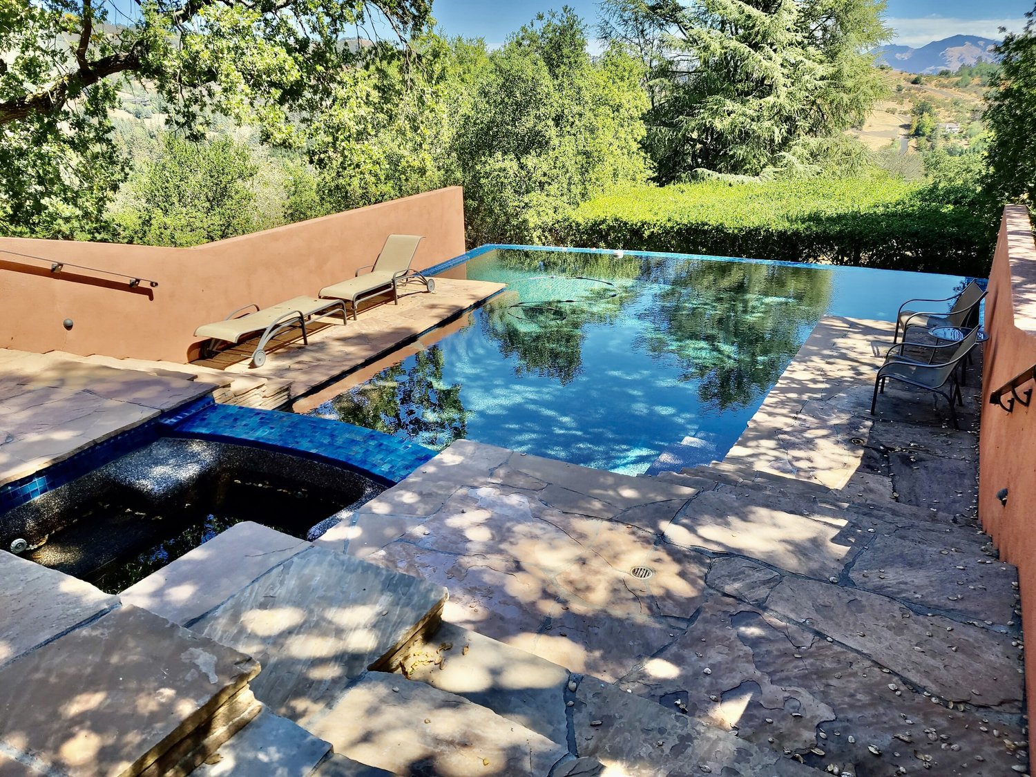 Pool and stone terrace set within a landscaped outdoor living space