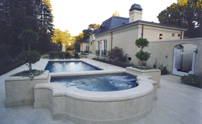 Custom home's outdoor terrace, swimming pool, and raised spa