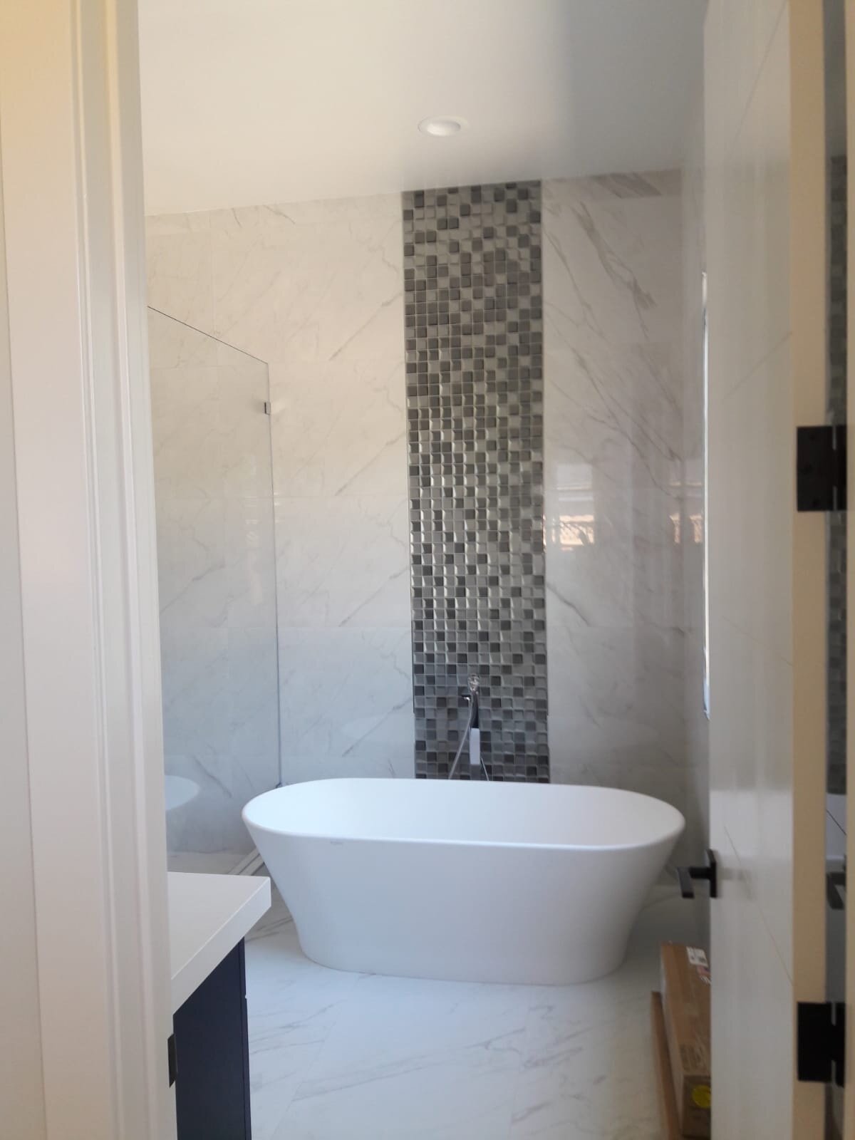 Freestanding bathtub and detailed tilework in a remodeled bathroom