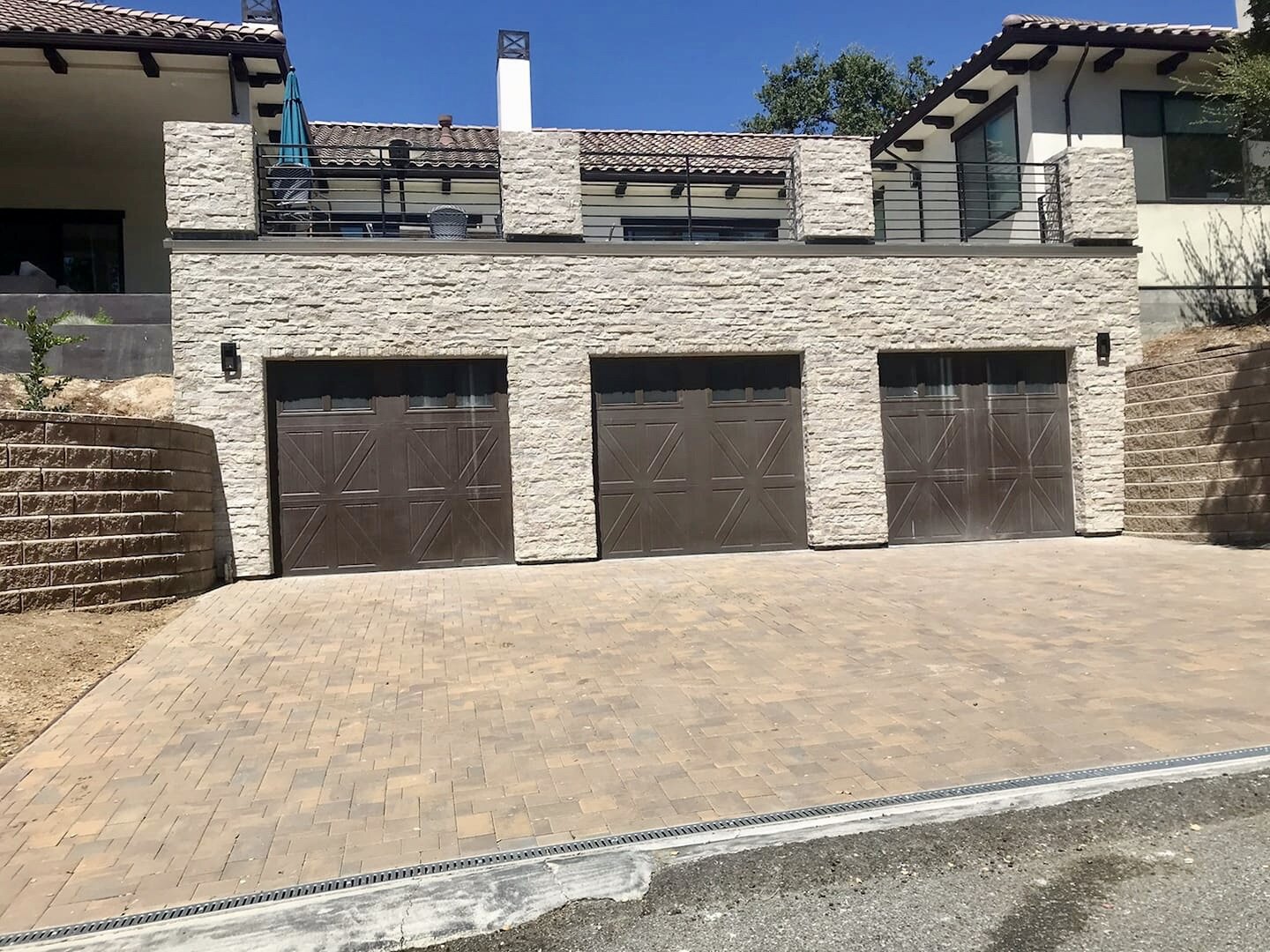 Custom stone-clad home with a generous driveway and garage